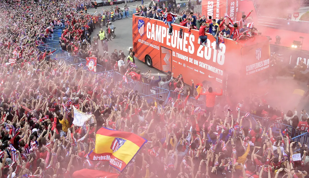 Warga Madrid tumpah ke jalan saat menyambut konvoi Atletico Madrid merayakan gelar Liga Europa di Madrid, Jumat (18/5/2018). Kota Madrid menjadi merah saat perayaan gelar juara Atletico. (AFP/Javier Soriano)