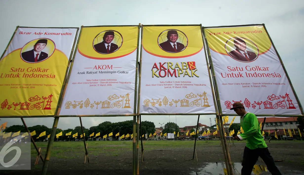 Seorang pekerja melintasi baliho Ade Komarudin di kawasan alun alun utara Yogyakarta, Jumat (11/3/2016). Ade Komarudin akan mendekalrasikan pencalonan ketua Umum DPP Golkar yang akan bertarung pada Munaslub 2016. (Liputan6.com/Boy Harjanto)