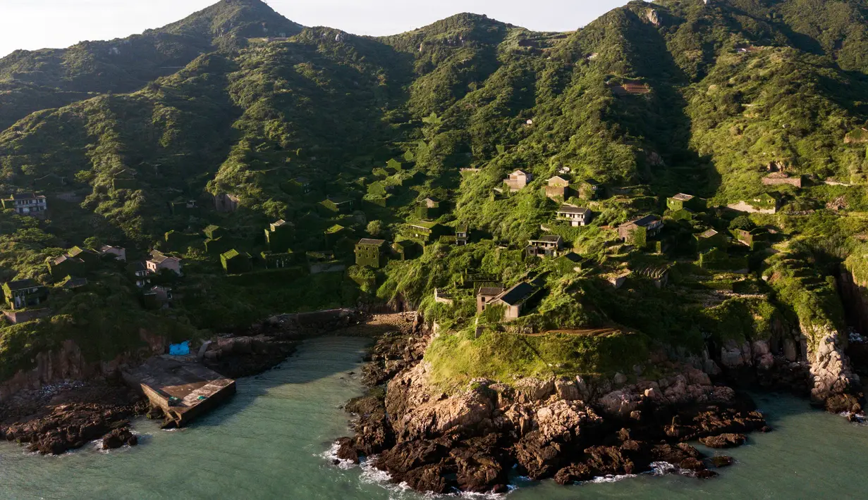 Pemandangan sejumlah rumah yang ditutupi tumbuhan di Houtouwan di pulau Shengshan, provinsi Zhejiang, China (1/6). Dulu penduduk di tempat ini ada sekitar 2.000 orang, namun kini tinggal segelintir saja. (AFP/Johannes Eisele)