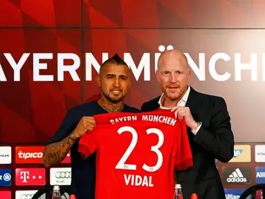 Gelandang Cile, Arturo Vidal, bersama Matthias Sammer berpose dengan jersey Bayern Munchen di Allianz Arena, Munchen, Jerman (28/7/2015). Bayern Munchen resmi mengontrak Vidal dengan kontrak selama empat musim. (Reuters/Michaela Rehl)