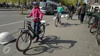 Seorang anak mengendarai sepeda di sekitar kawasan kota Amsterdam, Belanda, Kamis (20/4). Seluruh lapisan masyarakat, tua muda memilih menggunakan transportasi sepeda untuk bepergian. (Liputan6.com/Immanuel Antonius)