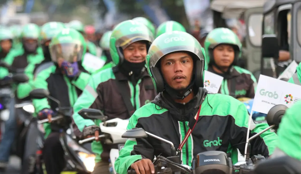 Mitra dari Grab turut konvoi saat obor Asian Games XVIII melintas di Kota Malang, Jawa Timur, Jumat (20/7/2018). Sebanyak 53 kota di Indonesia akan dilalui oleh obor Asian Games. (Bola.com/Aditya Wany)