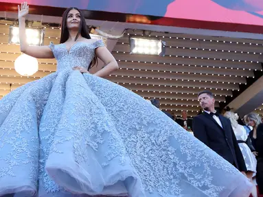 Aktris India Aishwarya Rai Bachchan melambaikan tangan ketika menghadiri pemutaran film Okja di Festival Film Cannes 2017, 19 Mei 2017. Aishwarya mengenakan gaun biru bermodel ball gown rancangan Michael Cinco pada hari ketiga acara itu (LOIC VENANCE/AFP)