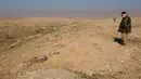 Anggota Kurdi Peshmerga memeriksa sebuah kuburan massal yang diduga lokasi makam anggota Yazidi Irak di pinggiran Sinjar, 30 November 2015. Pasukan Kurdi menemukan kuburan ini usai berhasil merebut kembali kota Irak dari militan ISIS. (Reuters/Ari Jalal)