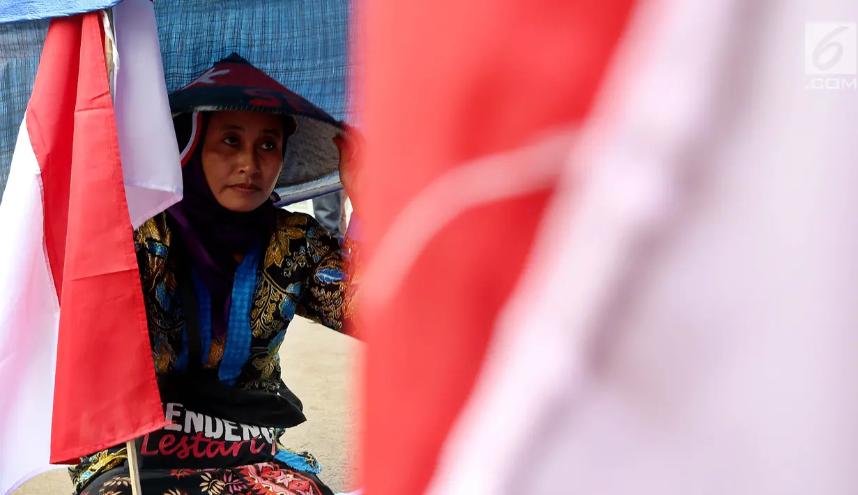 Seorang petani Kendeng kembali melakukan aksi protes di depan Istana Merdeka, Jakarta, Senin (4/9). Warga yang sebagian besar terdiri dari kaum perempuan itu meminta Presiden Jokowi menghentikan aktivitas pabrik semen di Rembang (Liputan6.com/Johan Tallo)