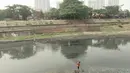 Dua pekerja membersihkan sampah yang mengotori aliran Kanal Banjir Timur (KBT), Jakarta, Sabtu (15/9). Banyaknya limbah rumah tangga dan limbah industri menyebabkan kanal pengendali banjir tersebut selalu tercemari sampah. (Liputan6.com/Immanuel Antonius)