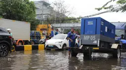 Sejumlah petugas dari Dinas Sumber Daya Air (SDA) DKI Jakarta melakukan upaya pemompaan air untuk mempercepat proses penanggulangan banjir. Tampak dalam foto, petugas Dinas Sumber Daya Air (SDA) DKI Jakarta menyalakan pompa air sebagai upaya penanggulangan genangan banjir yang belum surut di Jalan Gunung Sahari Raya atau tepat di depan Mangga Dua Square, Jakarta, Selasa (13/1/2026). (merdeka.com/magang/Rendi Saputra)
