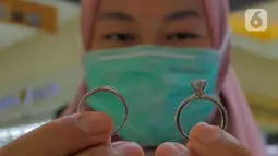 Pedagang menunjukkan perhiasan berbahan perak di gerai pusat perhiasan Cikini, Jakarta, Kamis (25/11/2021). Permintaan perak fisik global tahun 2021 diperkirakan melebihi satu miliar ons untuk pertama kalinya sejak tahun 2015. (Liputan6.com/Herman Zakharia)