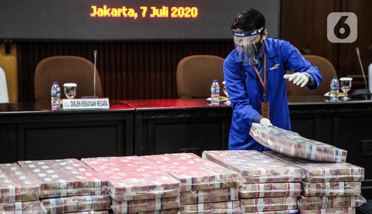 Petugas menata tumpukan uang saat rilis eksekusi barang bukti Honggo Wendratno di Kejaksaan Agung RI, Jakarta, Selasa (7/7/2020). Kejagung menyita barang bukti uang Honggo Wendratno sebesar Rp 97 miliar. (Liputan6.com/Faizal Fanani)