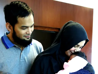 Teuku Wisnu dan Shireen Sungkar saat menggendong bayi seusai jumpa pres lahiran anak ke dua di RS Pondok Indah, Jakarta, Rabu (27/7). Shireen Sungkar melahirkan anak ke dua dengan panjang 50 cm dan beratnya 3,4 kg. (Liputan6.com/Herman Zakharia)