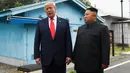 Presiden Amerika Serikat, Donald Trump bertemu dengan Pemimpin Korea Utara, Kim Jong-un di zona demiliterisasi Korea (DMZ), Desa Panmunjom pada Minggu (30/6/2019).  Ini adalah kali pertama seorang presiden AS menginjakkan kaki di negara tersebut. (AP Photo/Susan Walsh)