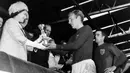 Kenangan Ratu Elizabeth II saat memberikan trofi Jules Rimet 1966 (saat ini Piala Dunia) ke kapten Inggris, Bobby Moore juga ditampilkan di 'big screen' stadion untuk mengenang kecintaan sang ratu kepada Timnas Inggris. (AFP)