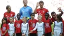 Pemain Bayern Muenchen Philipp Lahm, Manuel Neuer dan Thomas Mueller berfoto dengan anak-anak pengungsi (kaos merah) sebelum melawan FC Augsburg dalam lanjutan Liga Jerman. Sabtu (12/9/2015). (AFP Photo/DPA/Anandreas Gebert)