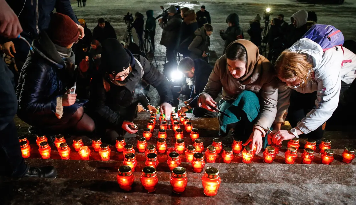 Warga menempatkan lilin di Katedral Kristus Juruselamat Moskow, Rusia, Senin (12/2). Mereka menyalakan 71 lilin sebagai simbol jumlah korban tewas dalam kecelakaan pesawat Rusia di Moskow. (Maxim ZMEYEV / AFP)