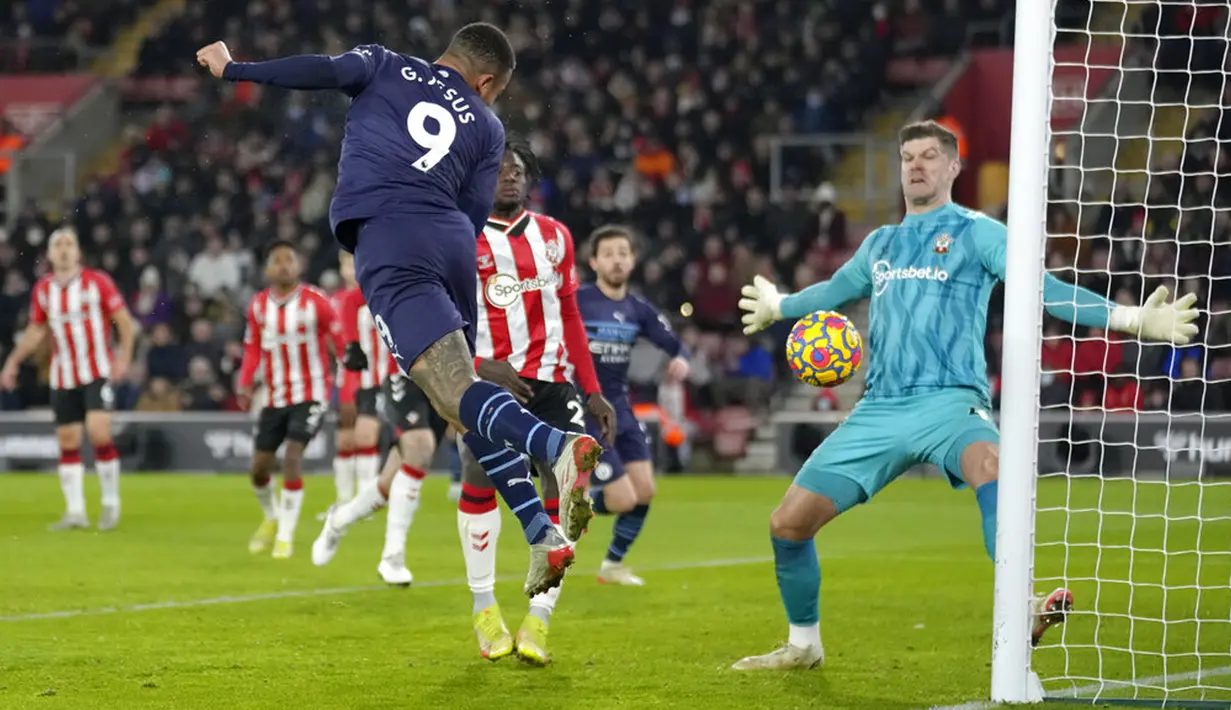 Pemain Manchester City Gabriel Jesus mencoba untuk mencetak gol tetapi tembakannya diblok kiper Southampton Fraser Forster (kanan) pada pertandingan sepak bola Liga Inggris di Stadion St Mary, Southampton, Inggris, 22 Januari 2022. Pertandingan berakhir imbang 1-1. (AP Photo/Kirsty Wigglesworth)