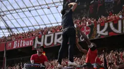 Pelatih Bayer Leverkusen, Xabi Alonso memimpin chant di depan para fans setelah laga lanjutan Liga Jerman 2024/2025 melawan Borussia Dortmund di BayArena, Leverkusen, Jerman, Minggu (11/05/2025) waktu setempat. (AFP/Ina Fassbender)