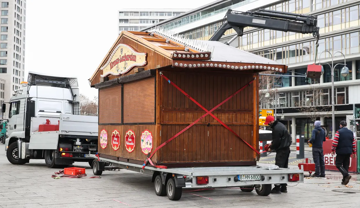 Para staf mengangkut sebuah pondok Natal di Berlin, Jerman, 16 Desember 2020. Jerman menerapkan karantina wilayah (lockdown) yang lebih ketat mulai 16 Desember 2020. (Xinhua/ShanYuqi)