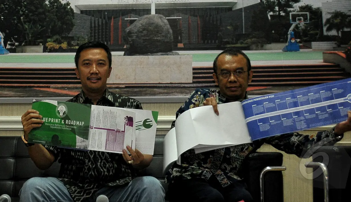Menpora Imam Nahrawi (kiri) menunjukkan Blue Print dan Road Map saat jumpa pers terkait pembentukan tim transisi PSSI di kantor Kemenpora, Jakarta, Jumat (8/5/2015). Menpora mengumumkan sejumlah nama yang menjadi Tim Transisi. (Liputan6.com/Yoppy Renato)