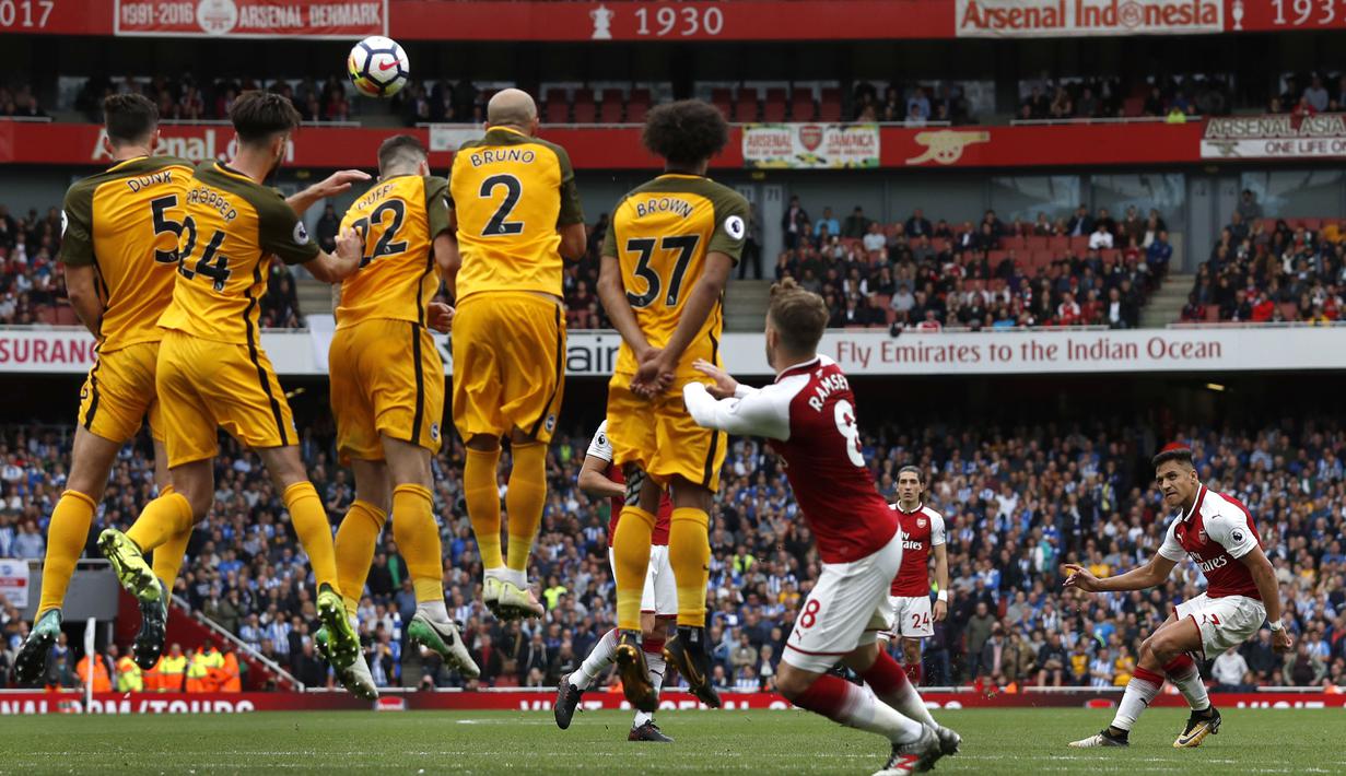 Pemain Arsenal, Alexis Sanchez (kanan) melakukan tendangan bebas saat melawan Brighton pada lanjutan Premier League di Emirates Stadium, London, (1/10/2017). Arsenal menang 2-0. (AFP/Adrian Dennis)