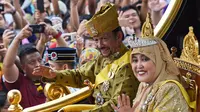 Sultan Hassanal Bolkiah dan Ratu Saleha Brunei saat naik kereta kerajaan melambaikan tangan kepada warga sekitar selama prosesi Golden Jubilee di Bandar Seri Begawan (5/10). Perayaan tersebut menandai 50 tahun bertahta. (AFP PHOTO / Roslan Rahman)