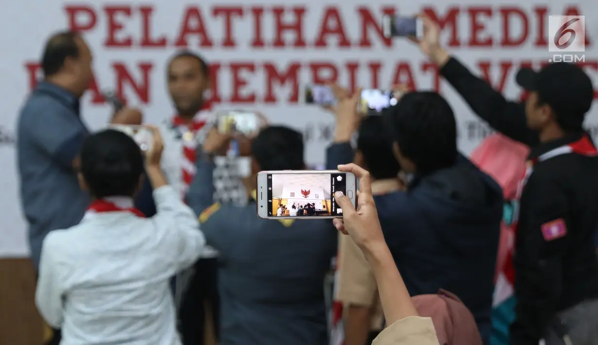Anggota Pramuka mempraktikkan cara mengambil gambar dengan ponsel di sela-sela materi Pelatihan Media Sosial dan Membuat Video Jilid 2, Jakarta, Sabtu (5/8). Pelatihan dalam rangka Raimuna Nasional XI Pramuka. (Liputan6.com/Helmi Fithriansyah)