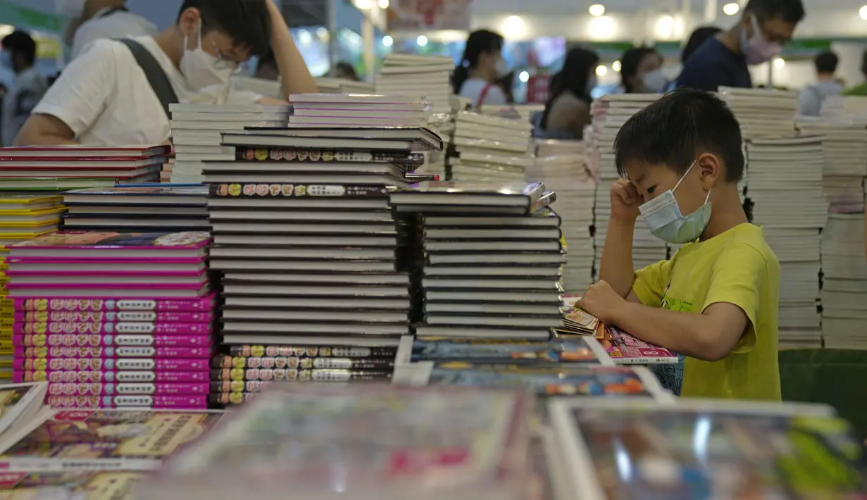 Seorang anak membaca di stan selama pameran buku tahunan di Hong Kong, Rabu (20/7/2022). Pameran Buku Hong Kong akan diadakan pada 20-26 Juli. (AP Photo/Kin Cheung)