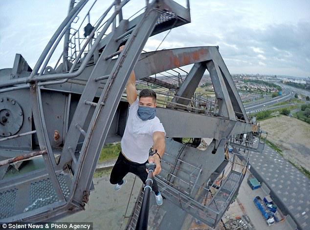 Dearing bergelantungan di atas ketinggian hanya dengan satu tangan | Photo: Copyright dailymail.co.uk