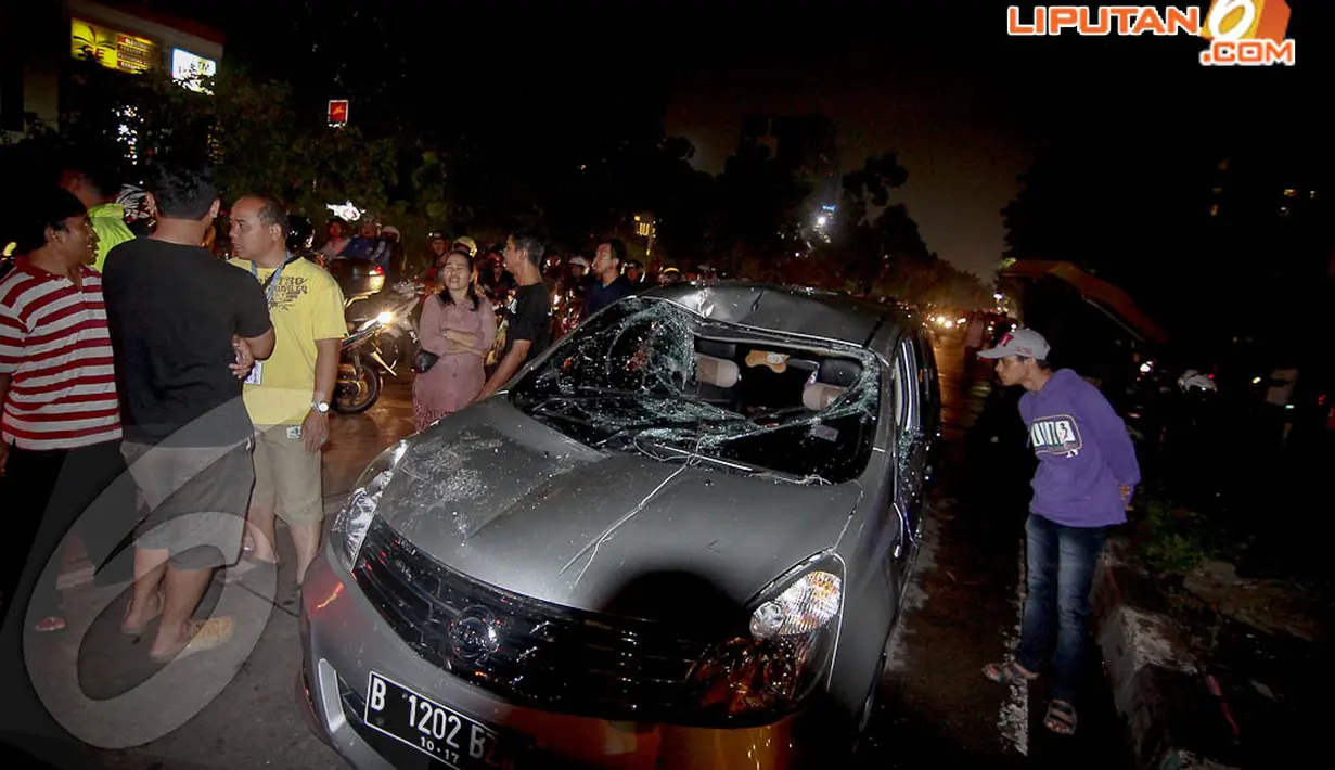 Sebuah mobil sedan terlihat rusak berat akibat tertimpa papan reklame, Selasa (22/4/14). (Liputan6.com/Faizal Fanani)
