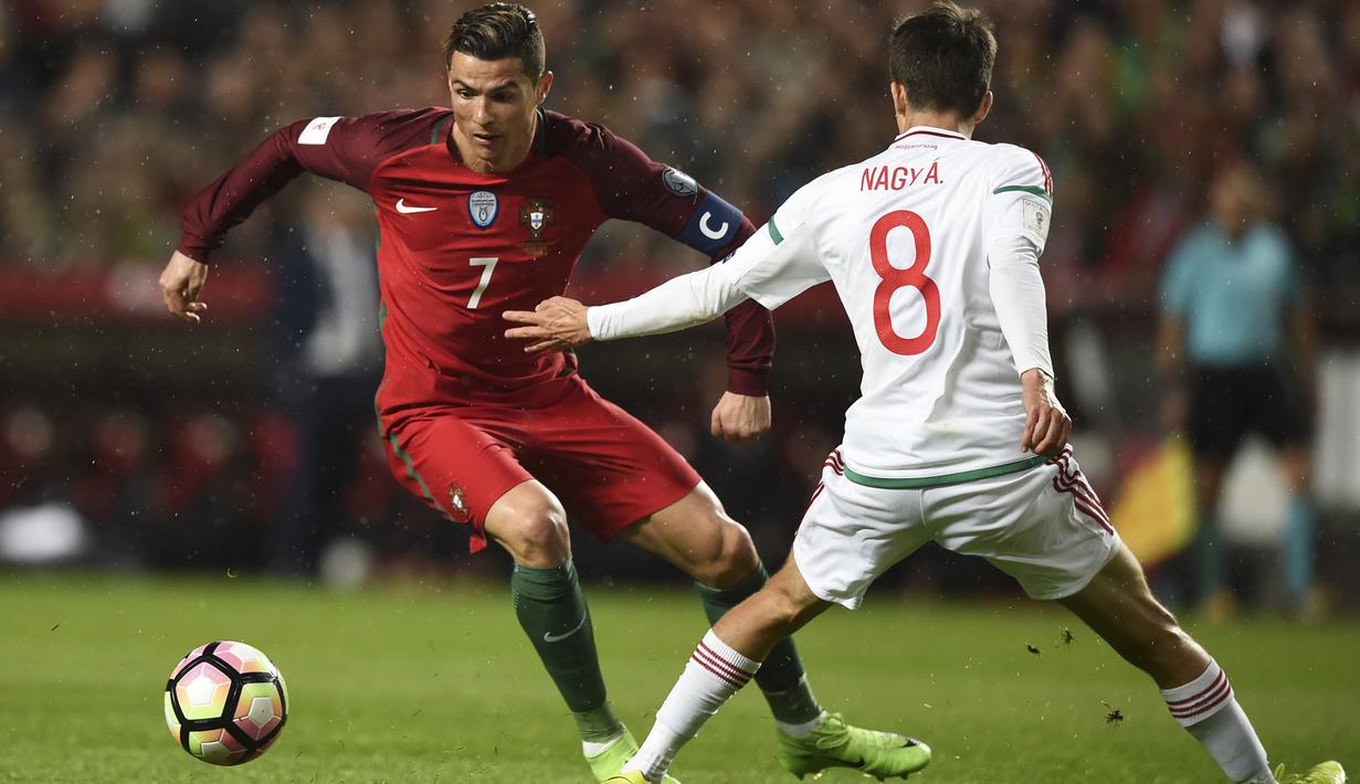 Striker Portugal, Cristiano Ronaldo, berusaha melewati gelandang Hongaria, Adam Nagy, pada laga kualifikasi Piala Dunia di Stadion Luz, Sabtu (25/3/2017). Cristiano Ronaldo meraih gelar pemain terbaik FIFA 2017. (AFP/Patricia De Melo Moreira)