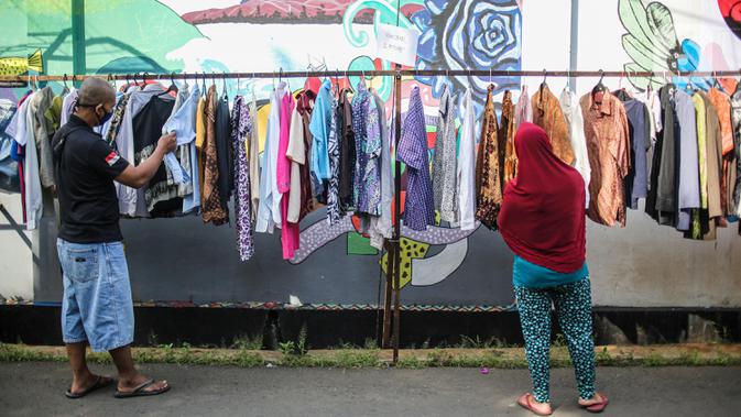 Warga memilih pakaian bekas layak pakai hasil sumbangan di RT 02 RW 04, Kelurahan Jati Padang, Jakarta, Jumat (22/5/2020). Pakaian bekas layak pakai serta bahan makanan disediakan bagi warga terdampak Pembatasan Sosial Berskala Besar (PSBB) untuk pencegahan COVID-19. (Liputan6.com/Faizal Fanani)