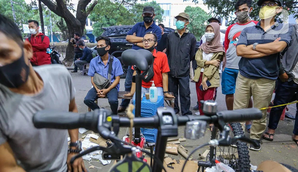 Warga antre menunggu pesanan sepeda yang sedang dirakit di Toko Sepeda Maju Royal, Cipondoh, Kota Tangerang, Kamis (11/6/2020). Menjelang new normal, toko sepeda yang buka sepada pukul 16.00 - 01.00 dinihari mulai diburu warga yang mencari sepeda lipat. (Liputan6.com/Fery Pradolo)