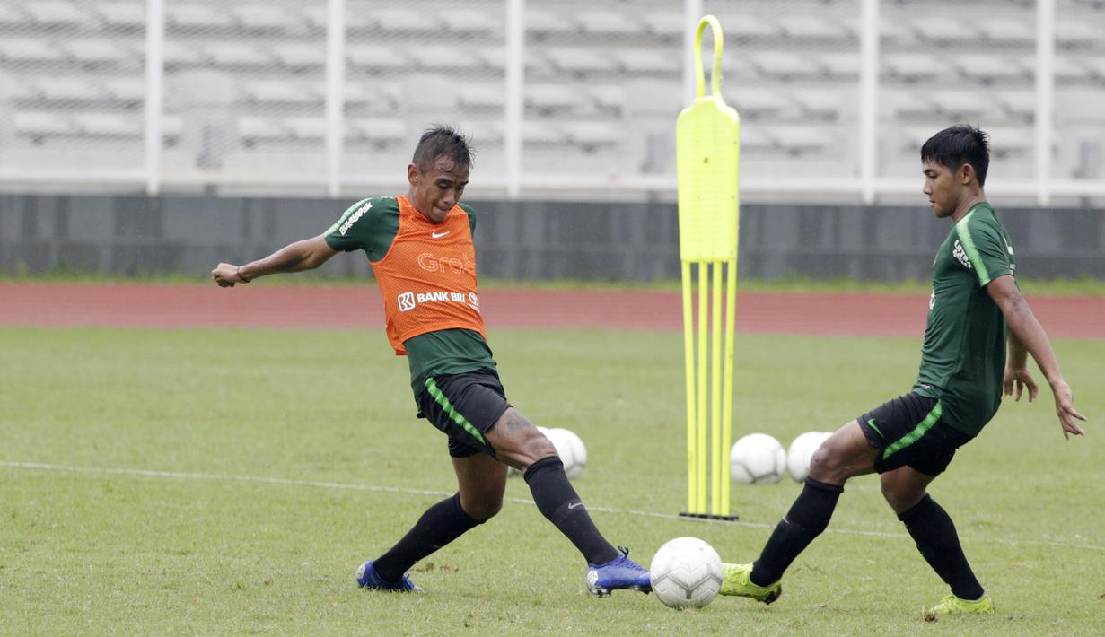 Pemain Timnas Indonesia U-22, Dallen Doke, berebut bola dengan Firza Andika, saat latihan di Stadion Madya, Senin (21/1). Pemain yang pernah merumput di Spanyol ini bertekad menembus skuat utama untuk tampil di Piala AFF U-22. (Bola.com/M Iqbal Ichsan)