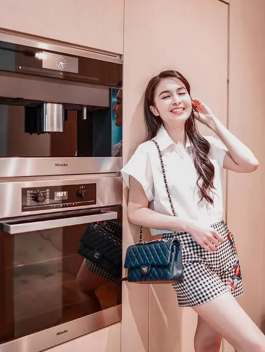 Sandra Dewi tampil menawan dengan mengenakan busana putih yang dipadu dengan celana kotak-kotak. (Foto: instagram.com/sandradewi88)