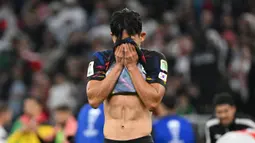 Pemain Korea Selatan, Jeong Woo-yeong menutup mukanya setelah kalah dari Yordania pada laga semifinal Piala Asia 2023 di Ahmad Bin Ali Stadium, Doha, Qatar, Selasa (06/02/2024). Korea Selatan kalah dengan skor 0-2. (AFP/Hector Retamal)