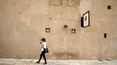 Seorang turis berjalan melewati sebuah bangunan tua di Al Bastakiya, sebuah tempat bersejarah di Dubai, UAE 7 Maret 2016. Dubai menjaga keindahan bangunan-bangunan bersejarahnya agar tetap memiliki pesona yang luar biasa. (REUTERS/Ahmed Jadallah)