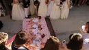 Bayi-bayi berusia hingga satu tahun ditaburi kelopak mawar sambil terlentang di atas matras usai dilompati pria berkostum setan selama festival melompati bayi (El Colacho) di desa Castrillo de Murcia, Spanyol, Minggu (18/6). (CESAR MANSO/AFP)