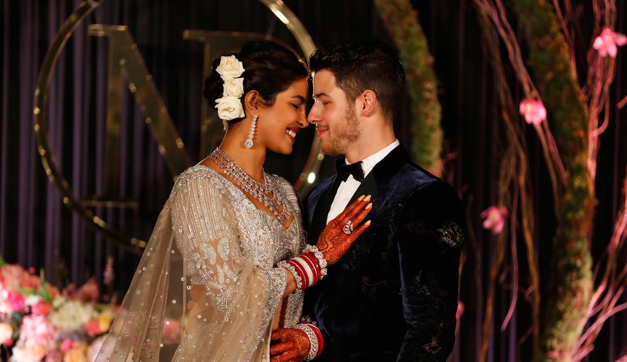 Aktris Bollywood Priyanka Chopra dan musisi AS Nick Jonas berpose saat resepsi pernikahan mereka di New Delhi, India, Selasa (4/12). Keduanya berkali-kali melepas senyum bahagia kepada publik. (AP Photo/Altaf Qadri)