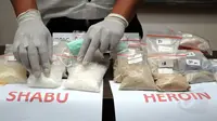 Salah satu petugas merapikan barang bukti narkotika jenis sabu saat jumpa pers di Dit Resnarkoba Polda Metro Jaya, Kamis (13/11/2014). Sebanyak 19,3 kg shabu dan 1,03 heroin disita Dit Resnarkoba Polda Metro Jaya. (Liputan6.com/Helmi Fithriansyah)