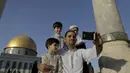 Muntasser Ne'erat (31) berfoto selfie dengan anak-anaknya di depan kubah Ash-Shakhrah di area Masjid , Yerusalem, 29 Juni 2015. (REUTERS/Ammar Awad) 