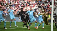 Bek Bayer Leverkusen asal Inggris #04, Jarell Quansah (tak terlihat), mencetak gol 1-0 melewati kiper Hoffenheim asal Jerman #37 Luca Philipp (kanan) dalam pertandingan divisi satu Bundesliga Jerman antara Bayer 04 Leverkusen dan TSG 1899 Hoffenheim di Leverkusen, Jerman Barat pada 23 Agustus 2025. (INA FASSBENDER/AFP)