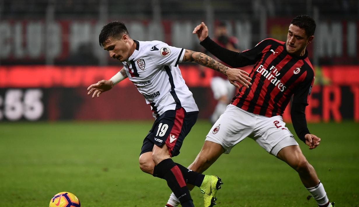 Bek AC Milan, Davide Calabria mencoba menghentikan pergerakan pemain Cagliari pada laga lanjutan Serie A yang berlangsung di stadion San Siro, Milan, Senin (11/2). AC Milan menang 3-0 atas Cagliari. (AFP/Marco Bertorello)