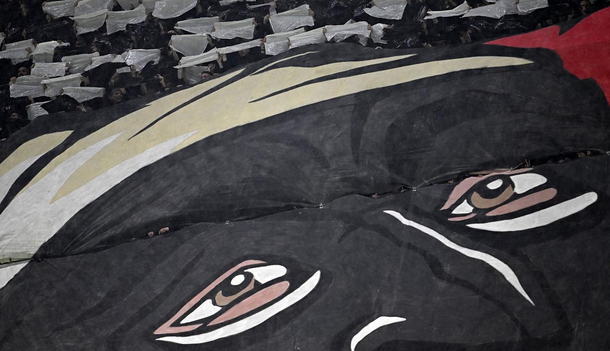 Koreografi fans AC Milan saat laga leg pertama perempat final Liga Champions 2022/2023 melawan Napoli di San Siro, Milan, Kamis (13/04/2023) dini hari WIB. Pertandingan tersebut berhasil dimenangkan oleh tuan rumah melalui gol tunggal Ismael Bennacer. (AFP/Gabriel Bouys)