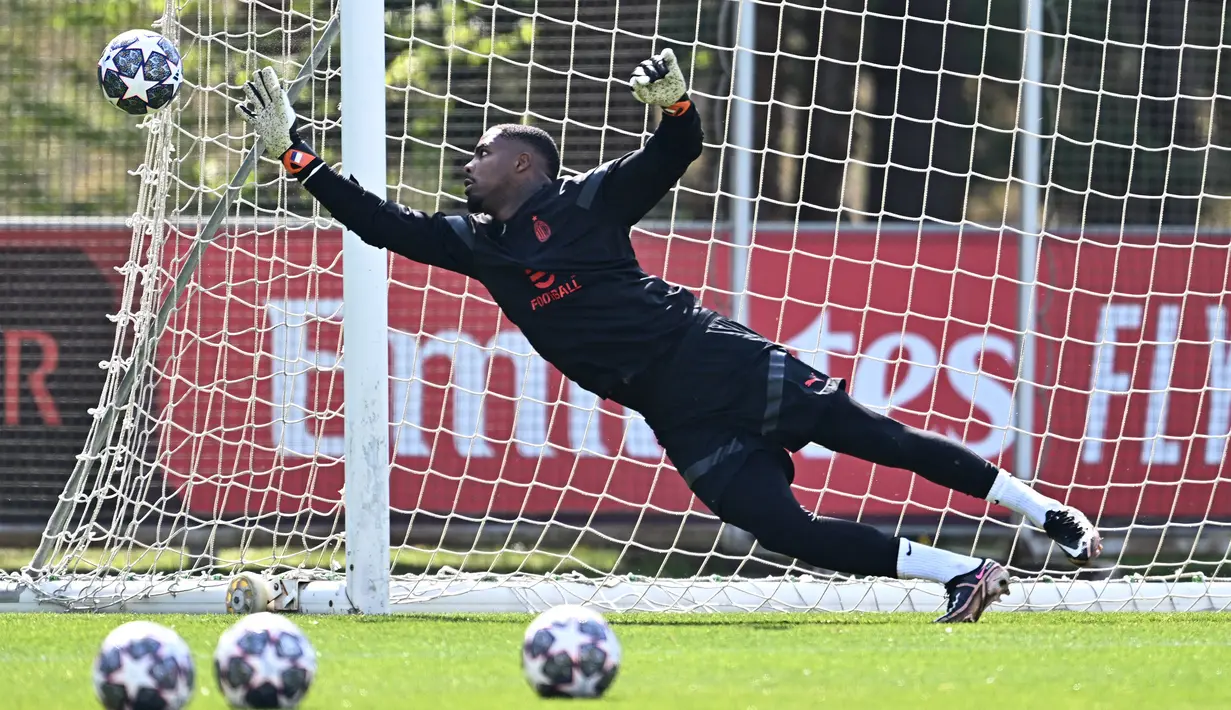 Penjaga gawang AC Milan, Mike Maignan, saat mengikuti latihan bersama di Milanello training center, Carnago, Milan, Selasa (11/4/2023). (AFP/Gabriel Bouys)