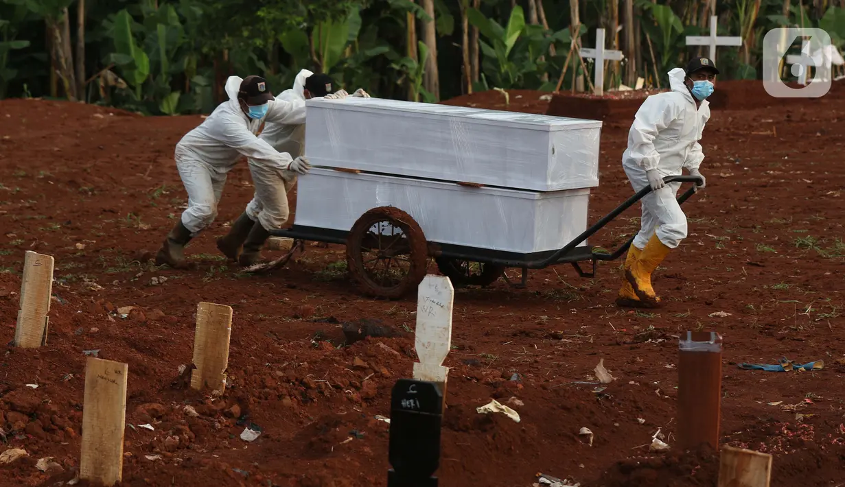 Petugas membawa dua peti jenazah yang akan dimakamkan dengan protokol COVID-19 di TPU Pondok Ranggon, Jakarta, Sabtu (17/10/2020). Petugas terpaksa menggunakan gerobak untuk membawa peti jenazah dikarenakan kondisi tanah yang lengket dan licin akibat diguyur hujan. (Liputan6.com/Helmi Fithriansyah)