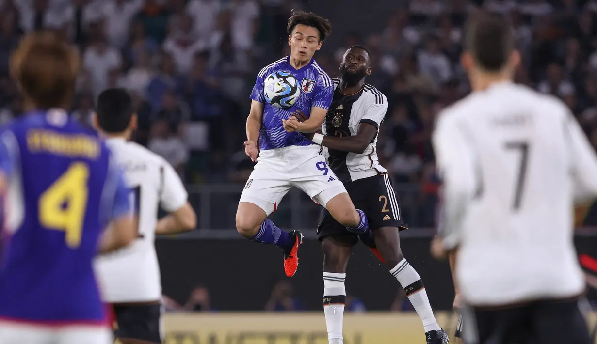 Pemain Timnas Jepang, Ayase Ueda (tengah kiri), melakukan duel udara dengan pemain Timnas Jerman, Antonio Ruediger, dalam pertandingan persahabatan yang berlangsung di Volkswagen Arena, Wolfsburg, Minggu (10/9/2023). (AFP/Ronny Hartmann)