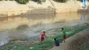 Anak-anak bermain di bantaran Sungai Ciliwung yang mengering, kawasan Kampung Melayu, Jakarta, Jumat (8/11/2019). Curah hujan yang tidak menentu menyebabkan sebagian bantaran Ciliwung masih mengalami kekeringan. (Liputan6.com/Immanuel Antonius)