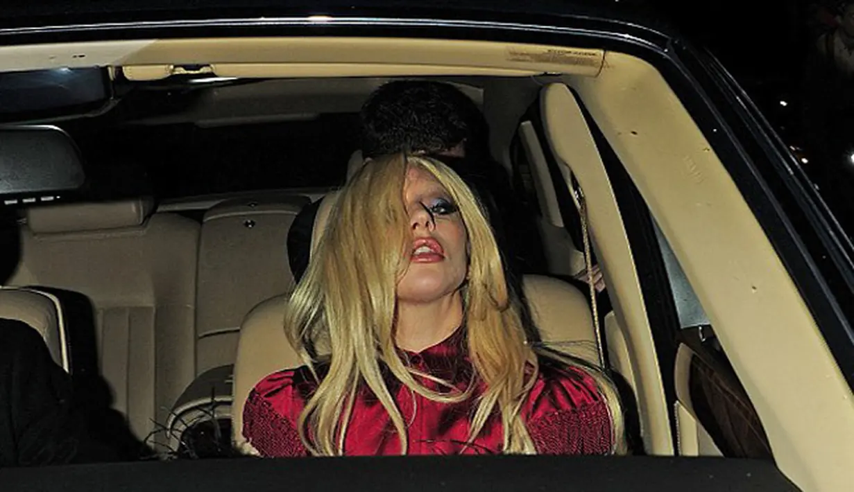 Penyanyi nyetrik Lady Gaga dengan menggunakan blus berwarna merah berada di dalam mobil usai membeli 4 kaleng bir di sebuah toko di London, Inggris. (Dailymail)
