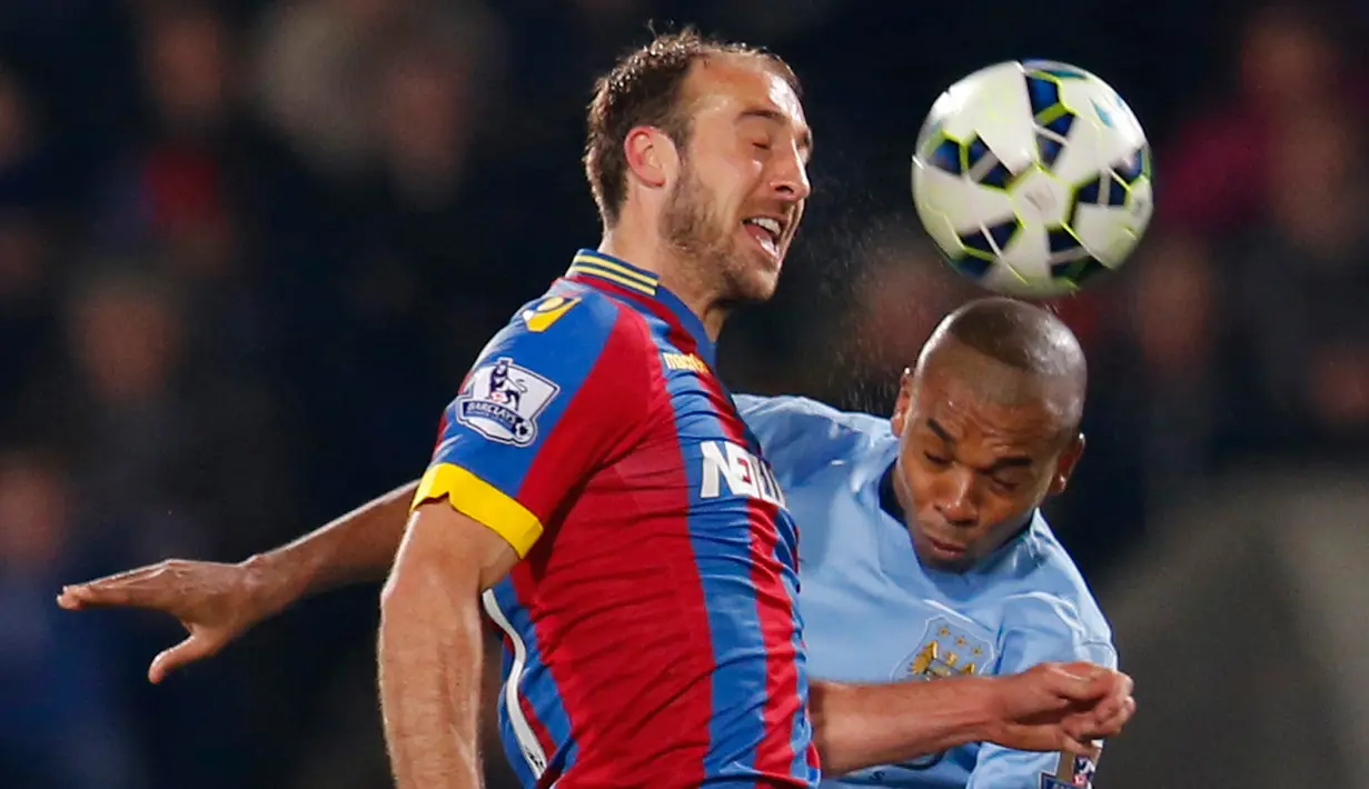 Gelandang Manchester City, Fernandinho berebut bola udara dengan pemain Crystal Palace Glenn Murray saat Laga Liga Premier Inggris di Selhurst Park Stadium, Inggris ( 6/4/2015). Crystal Palace menang 2-1 atas Manchester City. (Reuters/Suzanne)