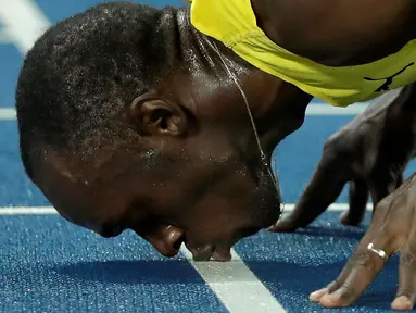 Sprinter Jamaika, Usain Bolt, mencium lintasan setelah meraih medali emas lari 200m putra Olimpiade Rio 2016 di Olympic Stadium, Rio de Janeiro, Brasil, (18/8/2016). (AP Photo/Matt Dunham)