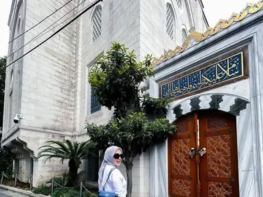 Syahrini berpose di depan Masjid Camii Tokyo. Dia mengenakan busana muslim putih yang dipadukan dengan hijab abu-abu. (Foto: Instagram/ princessyahrini)